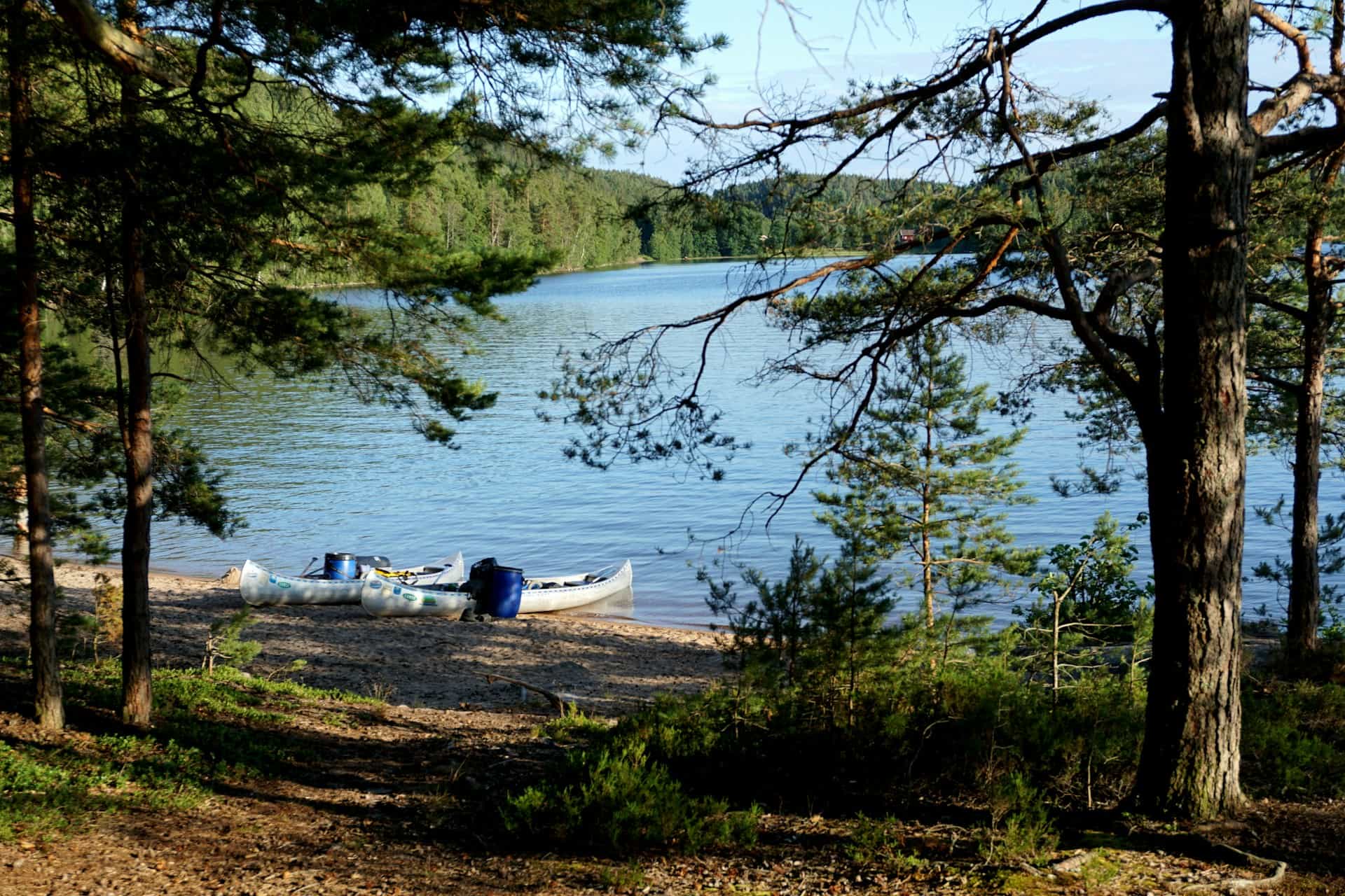 Zwei Kanus am Ufer eines ruhigen Waldsees in Schweden im Sommer